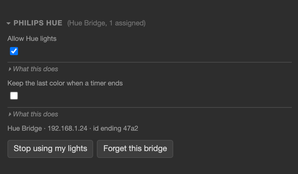 The Philips Hue section inside Display, opened: a heading reading Philips Hue, Hue Bridge, 1 assigned; an Allow Hue lights checkbox, ticked; a folded What this does explanation; a Keep the last color when a timer ends checkbox, unticked, with its own folded explanation; a line reading Hue Bridge, 192.168.1.24, id ending 47a2; and two buttons side by side, Stop using my lights and Forget this bridge.